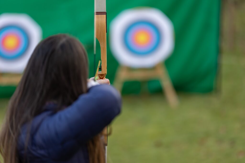 Person aiming at archery target.